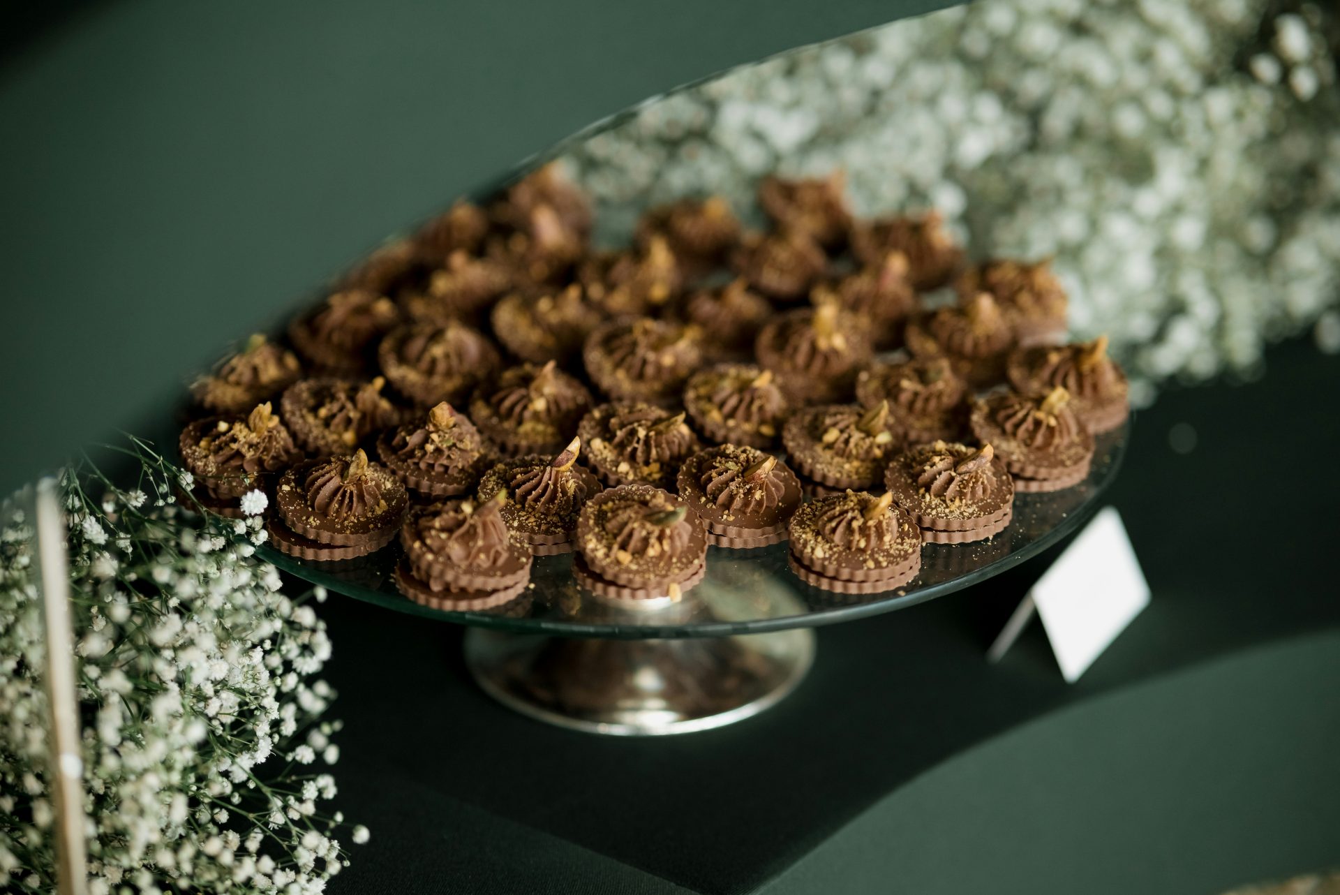 A tiered cake stand filled with chocolate cupcakes