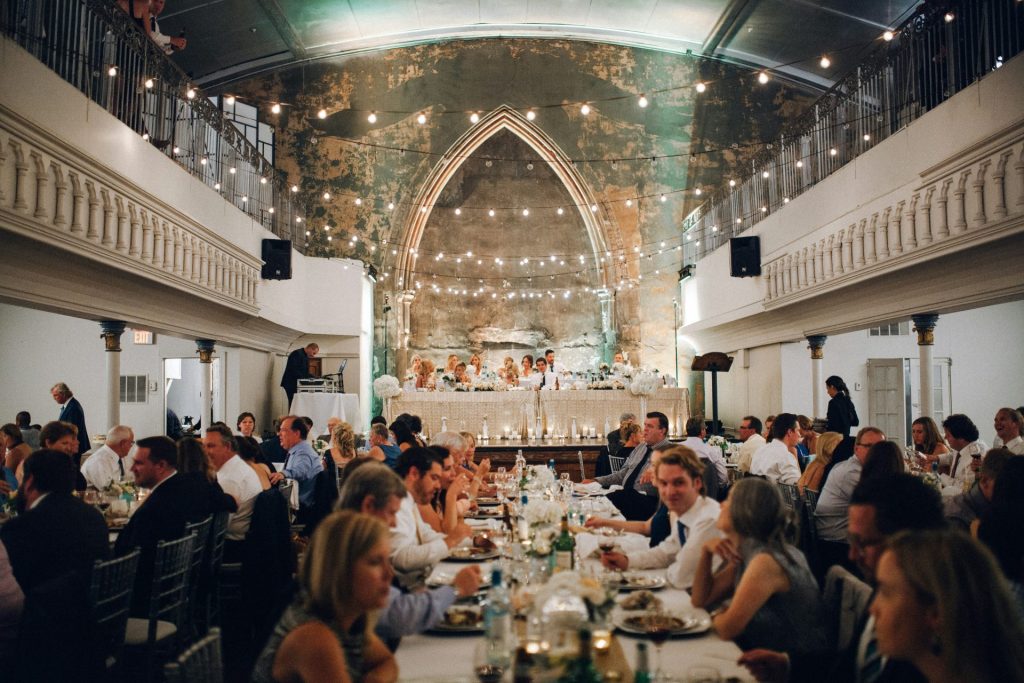 Wedding reception dinner with guests seated at tables.